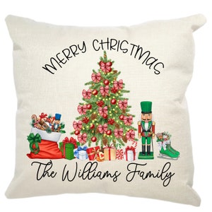 May include: A white throw pillow with a Christmas tree, a nutcracker, and a stocking filled with gifts. The text "Merry Christmas The Williams Family" is printed on the pillow.