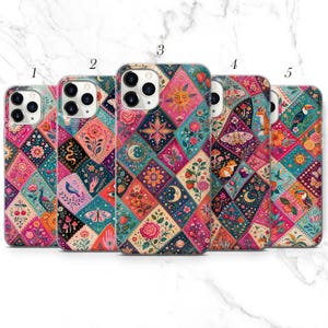 May include: Five smartphone cases arranged in a row, each featuring a vibrant, multi-coloured diamond-patterned quilt design. The patterns include illustrations of suns, moons, flowers, birds, foxes, butterflies, and mushrooms in shades of pink, blue, and orange.
