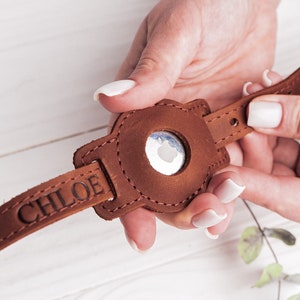 Könnte beinhalten: Ein braunes Lederarmband für die Apple Watch mit dem eingravierten Namen "CHLOE".