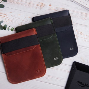 Puede incluir: Tres estuches de cuero en marr&oacute;n, verde y azul con bandas el&aacute;sticas negras e iniciales personalizadas. Los estuches est&aacute;n dise&ntilde;ados para guardar un lector electr&oacute;nico.