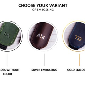 May include: Three leather camera straps with different embossing options. The first strap is green with black stitching and the initials "BA" embossed in black. The second strap is brown with white stitching and the initials "AM" embossed in silver. The third strap is black with blue stitching and the initials "YD" embossed in gold. The text below each strap reads "Emboss Without Color", "Silver Embossing", and "Gold Embossing".