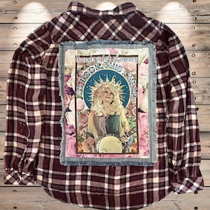 May include: A maroon and cream plaid flannel shirt with a denim patch featuring a portrait of a woman with the text "It costs a lot of money to look this cheap."