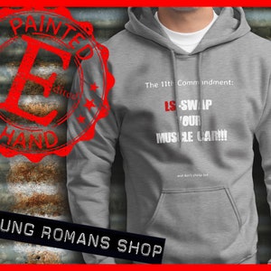 Puede incluir: Sudadera con capucha gris con texto blanco que dice "El 11º Mandamiento: LS-SWAP YOUR MUSCLE CAR!!! y no te pongas tacaño". La sudadera tiene un sello rojo desgastado con las palabras "Painted by Hand" en un círculo.