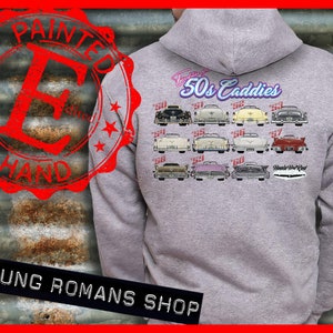 Könnte beinhalten: Grauer Kapuzenpullover mit einer Vintage-Illustration von Cadillac-Autos aus den 1950er Jahren. Der Text "Celebrating 50s Caddies" ist auf der Rückseite des Pullovers aufgedruckt.