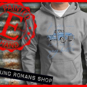 Könnte beinhalten: Ein grauer Kapuzenpullover mit einem hellblauen Vintage-Pickup-Truck-Motiv und dem Text "It could be newer, but it couldn't be any better." Der Hoodie hat eine Vordertasche und eine Kapuze mit Kordelzug.