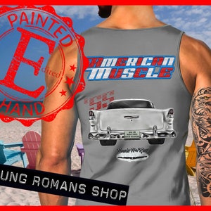May include: Gray sleeveless tank top with a white 1955 Chevrolet Bel Air car graphic on the back. The car has a red "Woodie Hot Rod" logo on the back bumper. The text "American Muscle" is printed in red, white, and blue above the car. The text "Painted by Hand" is in a red circle stamp on the left side of the image.
