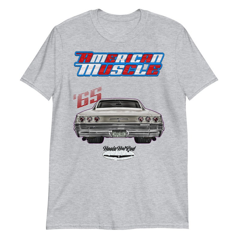 May include: A grey t-shirt with a vintage-style graphic of a 1965 Chevrolet Impala. The graphic features the text "American Muscle" in red, white, and blue, and the text "Woola Hot Rod" in black.