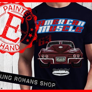 May include: A navy blue t-shirt with a red, white, and blue "American Muscle" graphic. The graphic features a vintage red Corvette with the text "63" above it. The t-shirt also has a red, white, and blue star design and the text "Painted by Hand" in a red circle.