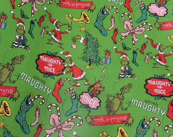 May include: Green wrapping paper with a repeating pattern of cartoon characters, Christmas trees, candy canes, and stockings. The text includes "Naughty or Nice" and "Work in Progress".