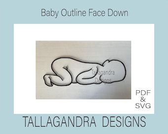 May include: Black and white outline of a baby lying on its stomach with its face turned to the side. The image is titled "Baby Outline Face Down" and includes the text "Tallagandra Designs".