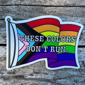 Könnte beinhalten: Ein Aufkleber mit einer Regenbogenflagge und dem Text "Diese Farben laufen nicht."