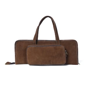 May include: A brown leather carrying case with a zipper closure and a smaller, attached pouch. The case has a top handle.