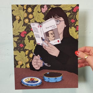 Peut inclure: Illustration d'une personne lisant un livre intitulé "Knut Hamsun La Faim" avec une cuillère au-dessus d'une boîte de caviar. L'œuvre présente un fond d'écran floral et une boîte de caviar bleue.