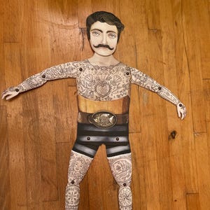 Bambola di carta snodabile vintage fatta a mano con un uomo forte tatuato