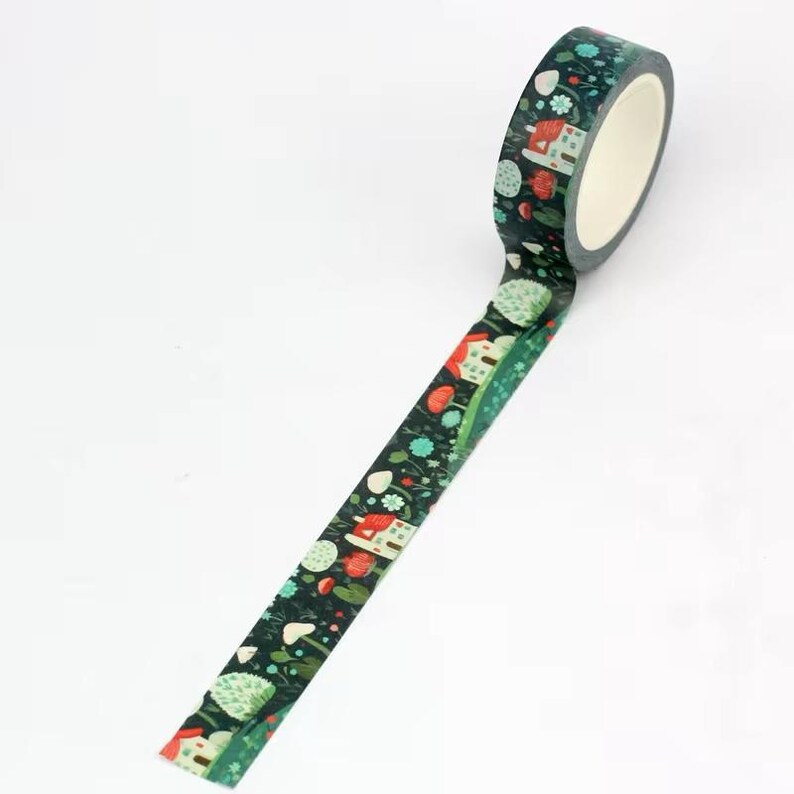May include: A roll of decorative washi tape with a dark teal background and a repeating pattern of small houses, trees, and flowers in red, white, and teal. The tape is unrolled, showing the pattern in detail.