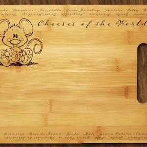 May include: A rectangular bamboo cutting board with a handle, featuring a cartoon mouse holding a cheese. The words "Cheeses of the World" are inscribed, along with various cheese names around the edges. A decorative kitchen item.
