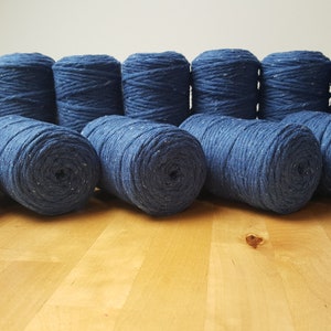 May include: Twelve spools of blue yarn with a speckled texture.