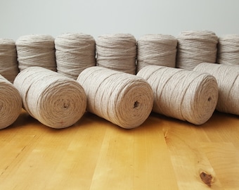 May include: A collection of 12 spools of natural beige twine, each wound tightly and ready for crafting projects.
