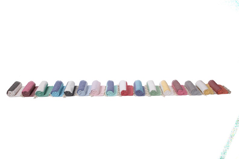 May include: A row of 15 rolled up towels in various colors, including black, pink, green, blue, white, gray, yellow, and red.