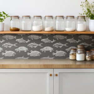 May include: A kitchen backsplash with a gray background and a white pattern of fish and turtles. There are eight glass jars with lids on a wooden shelf above the backsplash.