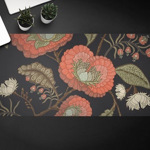May include: A dark blue desk mat with a floral pattern featuring pink, red, and green flowers. The flowers are stylized and have a vintage look.
