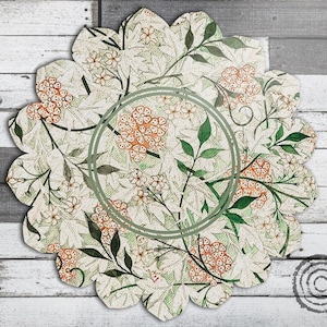 Peut inclure: Un dessous de plat à bord festonné avec un motif floral. Le design présente un fond crème avec un motif répété de grappes de fleurs orange, de feuilles vertes et de fleurs blanches. Un cercle vert est au centre.