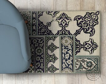 Könnte beinhalten: Ein rechteckiger Teppich mit einem komplizierten Blumenmuster in Marine-, Grün- und Cremetönen. Das Design zeigt stilisierte Blumen und Blätter, die in einem sich wiederholenden Muster angeordnet sind. Der Teppich wird teilweise von einem hellblauen Stuhl bedeckt.