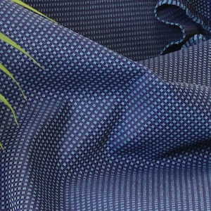 Puede incluir: Un primer plano de una tela azul y blanca con estampado, con el texto "ROK" y "CHIESU" en las esquinas inferiores. La tela se describe como 100% PES teñido en solución para exteriores, con una anchura de 165 cm, un peso de 264 gramos por metro cuadrado y una calificación Martindale de 40.000 frotamientos.