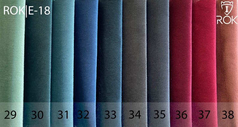 May include: A fabric swatch card displaying ten different colours, ranging from light green to brown. The card is labelled "ROK E-18" and the colours are numbered 29 through 38.