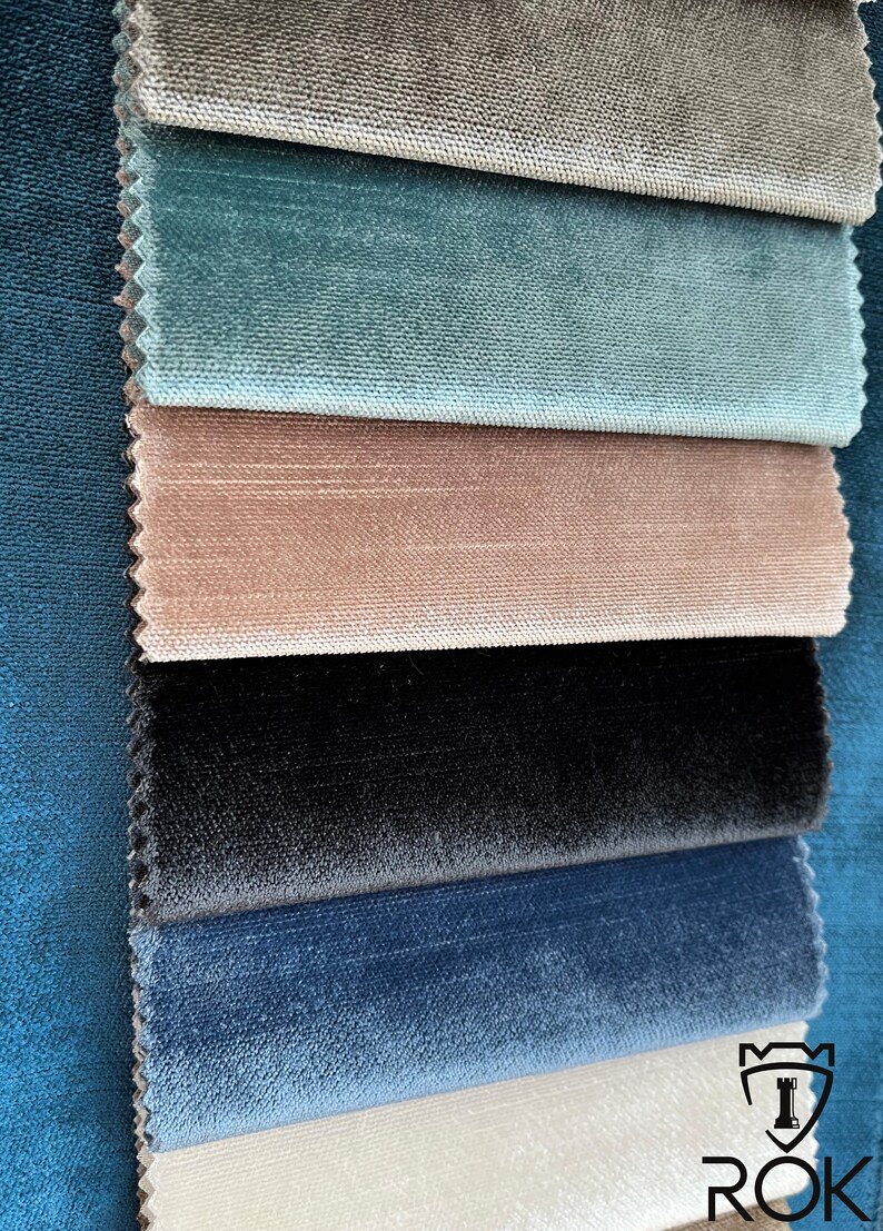 May include: A close-up of seven fabric swatches in different colors and textures. The swatches are arranged in a stack, with the top swatch being a light brown color and the bottom swatch being a white color. The swatches are all velvet.
