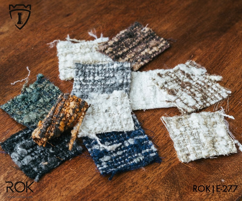 Puede incluir: Una colecci&oacute;n de muestras de tela texturizada en varios colores, incluyendo blanco, azul, marr&oacute;n y gris. Las muestras tienen una apariencia tejida y est&aacute;n dispuestas sobre una superficie de madera. El texto "ROK | E-277" es visible en la esquina inferior derecha.