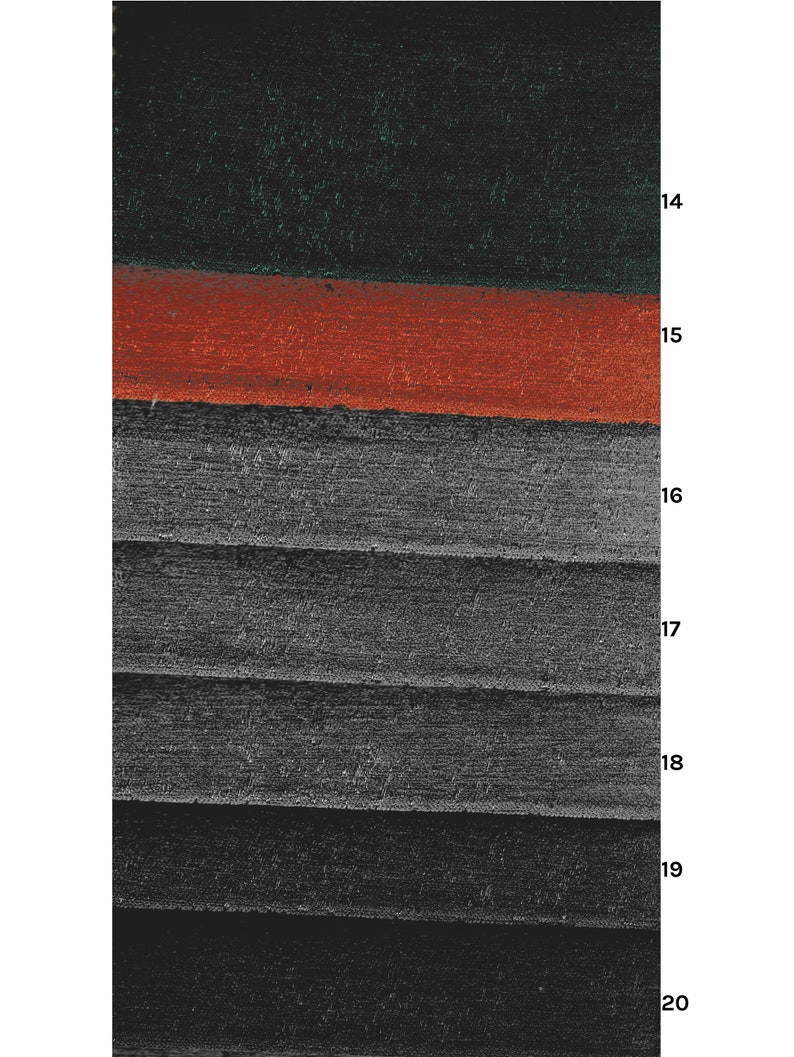 May include: Close-up of a layered fabric with a dark green, red, and gray color scheme. The fabric has a textured surface and appears to be woven.