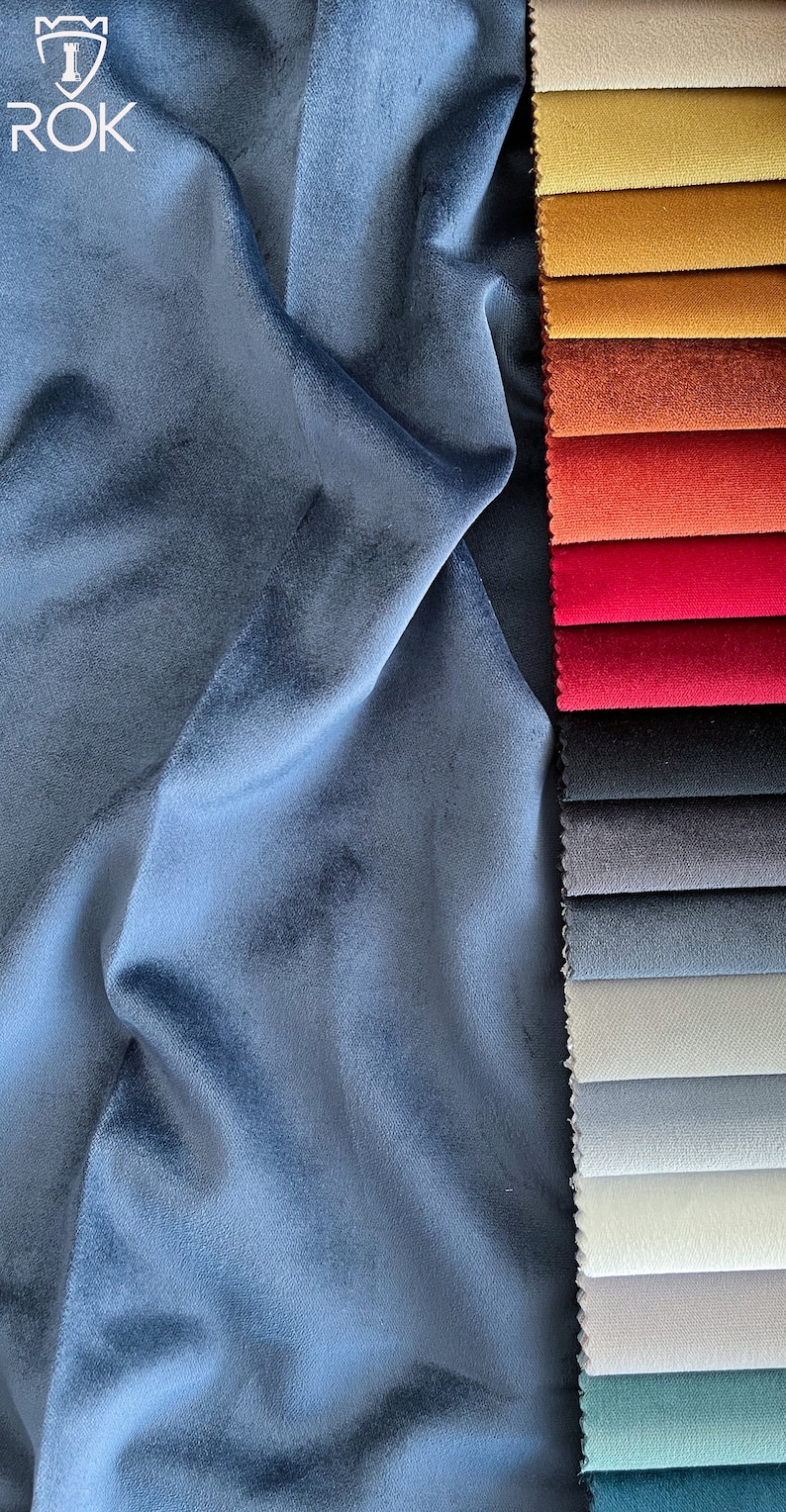 May include: A close-up of a blue velvet fabric swatch next to a selection of fabric swatches in various colours, including beige, yellow, orange, red, grey, and green.