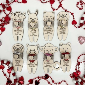 May include: A set of eight wooden Valentine's Day cards with different animal designs. Each card has a small pocket for a treat and a personalized message. The cards are decorated with red hearts and the text "You're the PURRFECT friend from: Kindy", "You're the COOLEST Valentine from: Alex", "You MOOOVE me from: Lex", "You're a LLAMA my fun from: Emry", "I like you SLOW much from: Max", "HIPPO Valentine's Day from: Kaci", "I'm BANANAS for you from: Landon", "You are the BEARY best from: Maryn".