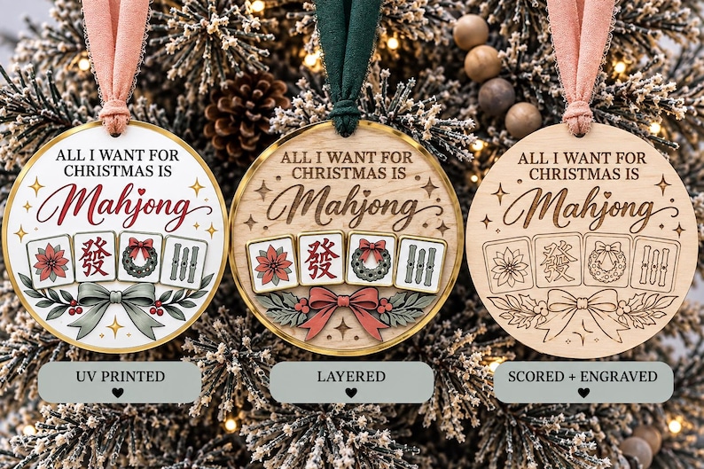 May include: Three round Christmas ornaments with pink and green ribbons. Each features the text "ALL I WANT FOR CHRISTMAS IS Mahjong" and an illustration of four mahjong tiles, a bow, and holly. The ornaments are UV printed, layered, or scored.