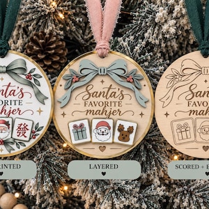 May include: Three round wooden ornaments featuring the text Santa's Favorite mahjer. The left ornament is UV printed with colorful graphics. The center ornament is layered with raised elements. The right ornament is scored and engraved with line art.
