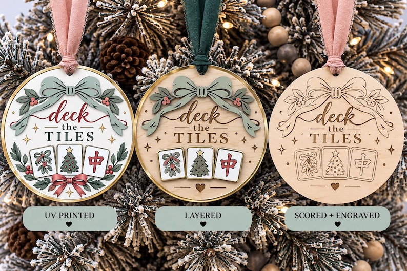 May include: Three circular ornaments with pink or green ribbons. Each features the text "deck the TILES" and three mahjong tiles depicting mistletoe, a Christmas tree, and a red character. One is UV printed, one is layered, and one is engraved.