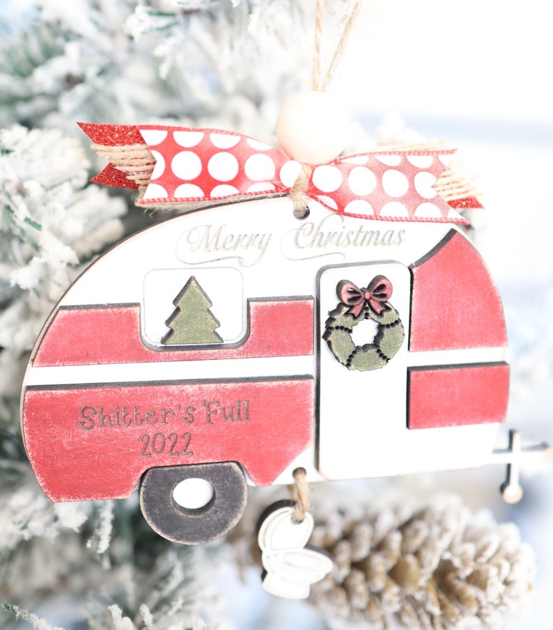 May include: Red and white wooden camper Christmas ornament with the text "Merry Christmas" and "Shitter's Full 2022".