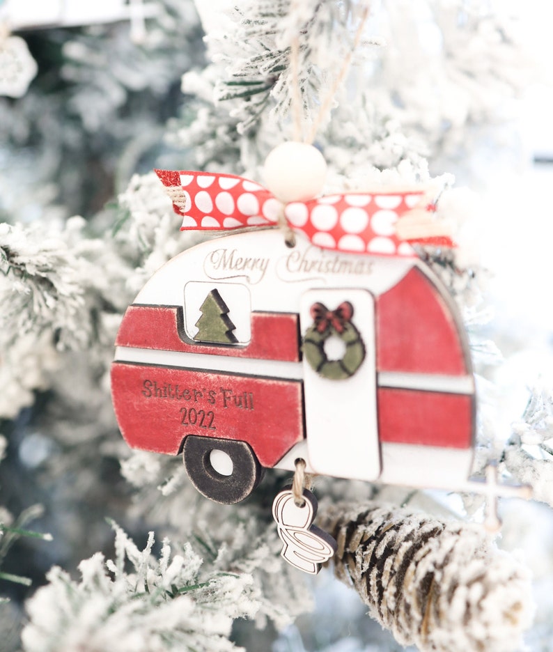 May include: Red and white wooden camper Christmas ornament with the text "Merry Christmas" and "Shifter's Full 2022".
