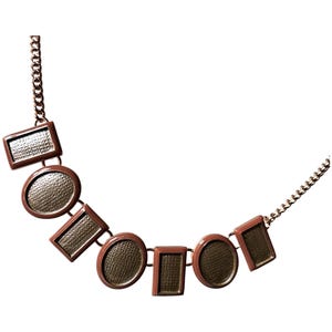 Puede incluir: Un collar marrón con formas geométricas, incluyendo rectángulos y círculos, conectados por una cadena. Las formas tienen un interior texturizado y estampado. El collar es un accesorio de moda.