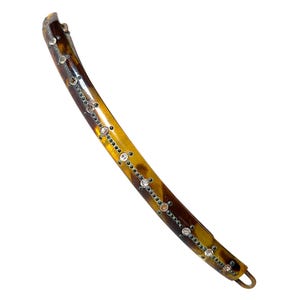 Puede incluir: Horquilla curva para el cabello con un patrón de carey. La horquilla está adornada con pequeños diamantes de imitación transparentes y un cierre de metal dorado. La horquilla mide aproximadamente 13 cm de largo.