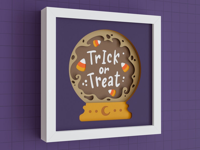 May include: A white frame with a brown paper mache Halloween-themed papercraft inside. The papercraft is a brown and orange globe with the words "Trick or Treat" and candy corn decorations.