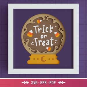 May include: A brown papercraft Halloween-themed snow globe with the text "Trick or Treat" and candy corn decorations. The snow globe is on a yellow base with a crescent moon.