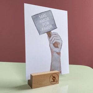 Cartolina con la scritta “Mas Amor por favor” - “Più amore, per favore”.