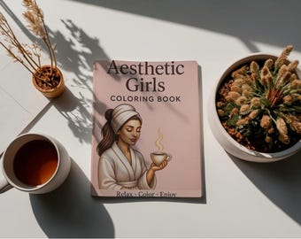 Op de afbeelding: Aesthetic Girls kleurboek met een vrouw op de cover, die een kopje thee vasthoudt. Het boek ligt op een wit oppervlak, naast een kopje thee, een kleine plant en een decoratieve plant.