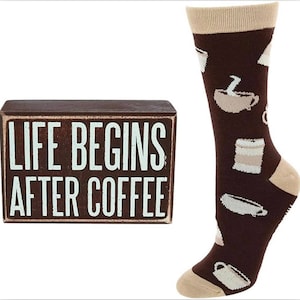 May include: A wooden box sign with the text "Life Begins After Coffee" in white lettering on a brown background. A pair of brown socks with a white coffee cup design.