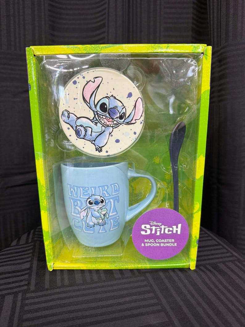 Puede incluir: Un juego de taza, posavasos y cuchara de Disney Stitch. La taza azul claro tiene el texto "WEIRD BUT CUTE" y un gr&aacute;fico de Stitch. El posavasos presenta a Stitch. El juego est&aacute; empaquetado en una caja verde y amarilla.