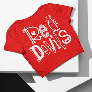 May include: Red t-shirt with white text that says "Red Devils" on the back.