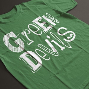 May include: Green t-shirt with the words "Green Devils" printed in white on the front.