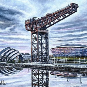 May include: A white ceramic mug with a black handle and the text "But First, Coffee" in a black, handwritten-style font. The mug is on a white surface.